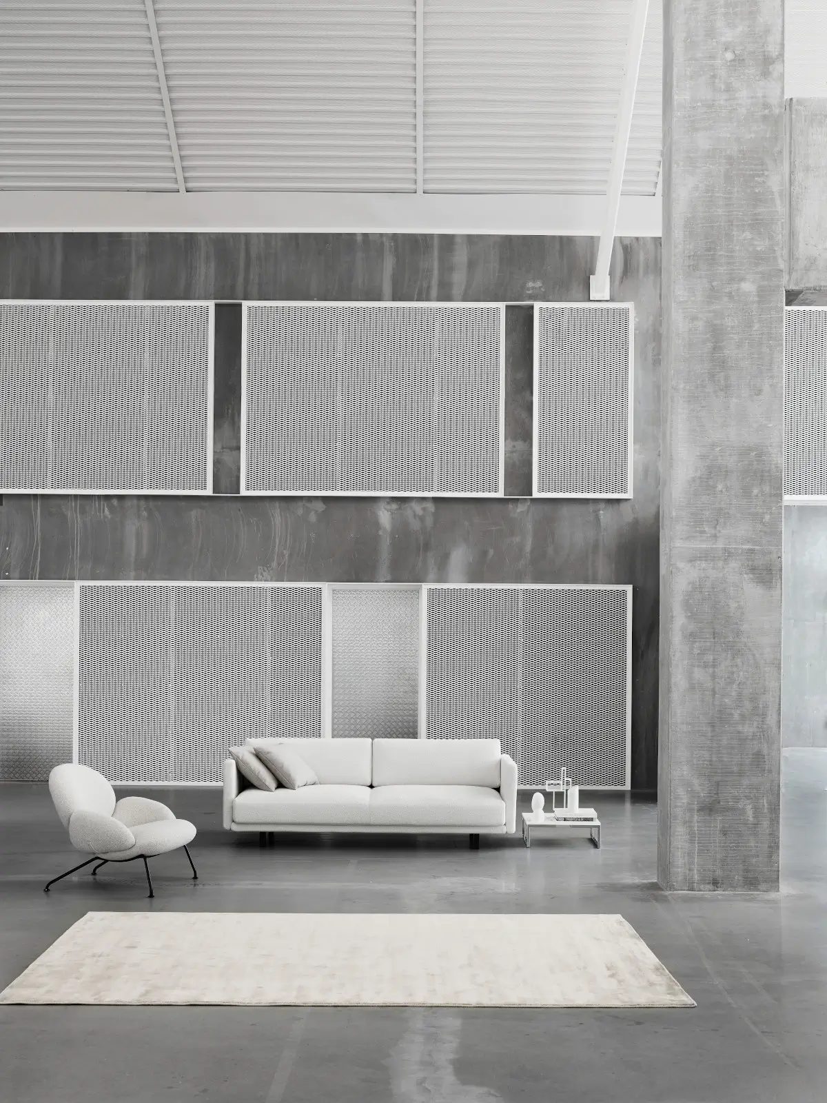Softline Baixa Sessel in Hellgrau in einem großzügigen modernen Wohnambiente mit Sofa, Beistelltisch und hellem Teppich.