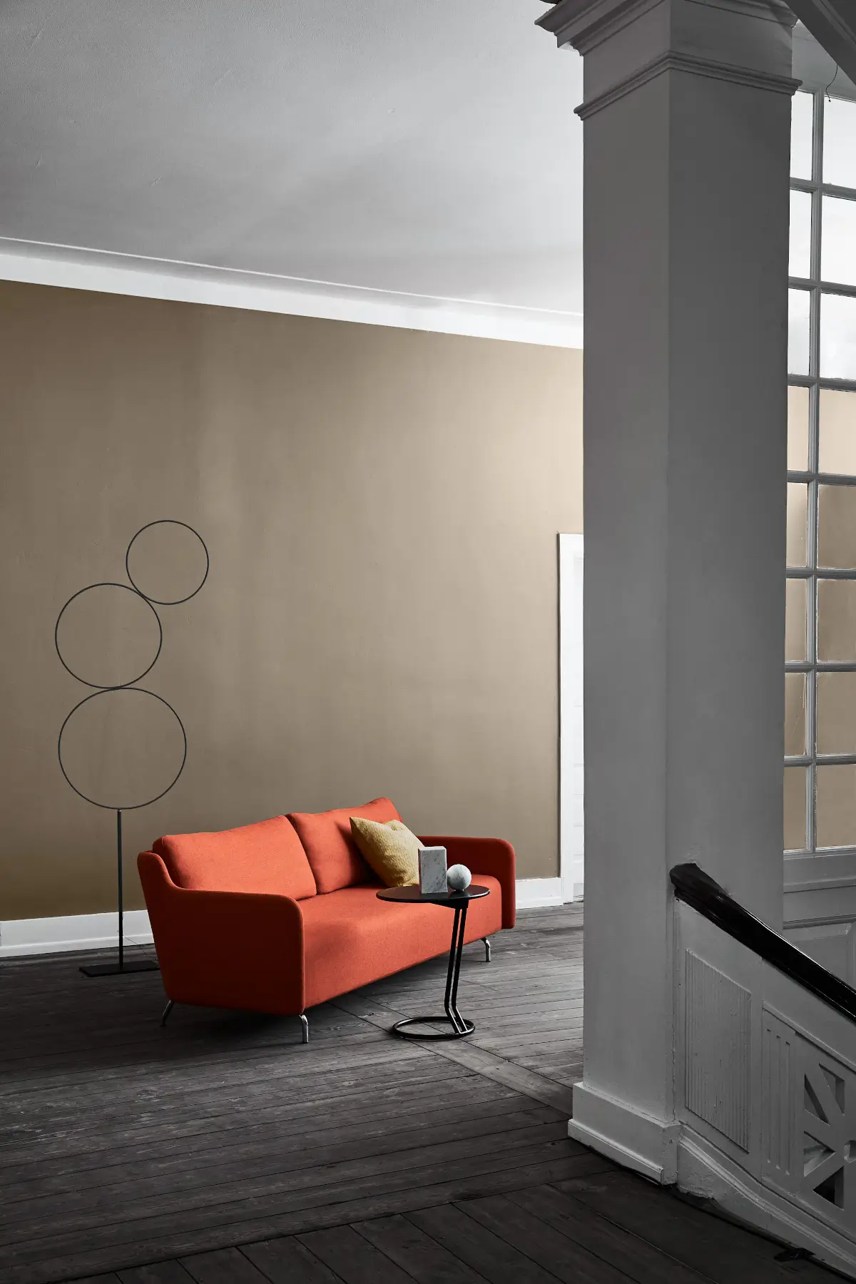 Softline Venus Sofa in Orange in einem stilvollen Wohnambiente mit dunklem Holzboden, Beistelltisch und dekorativen Kissen.