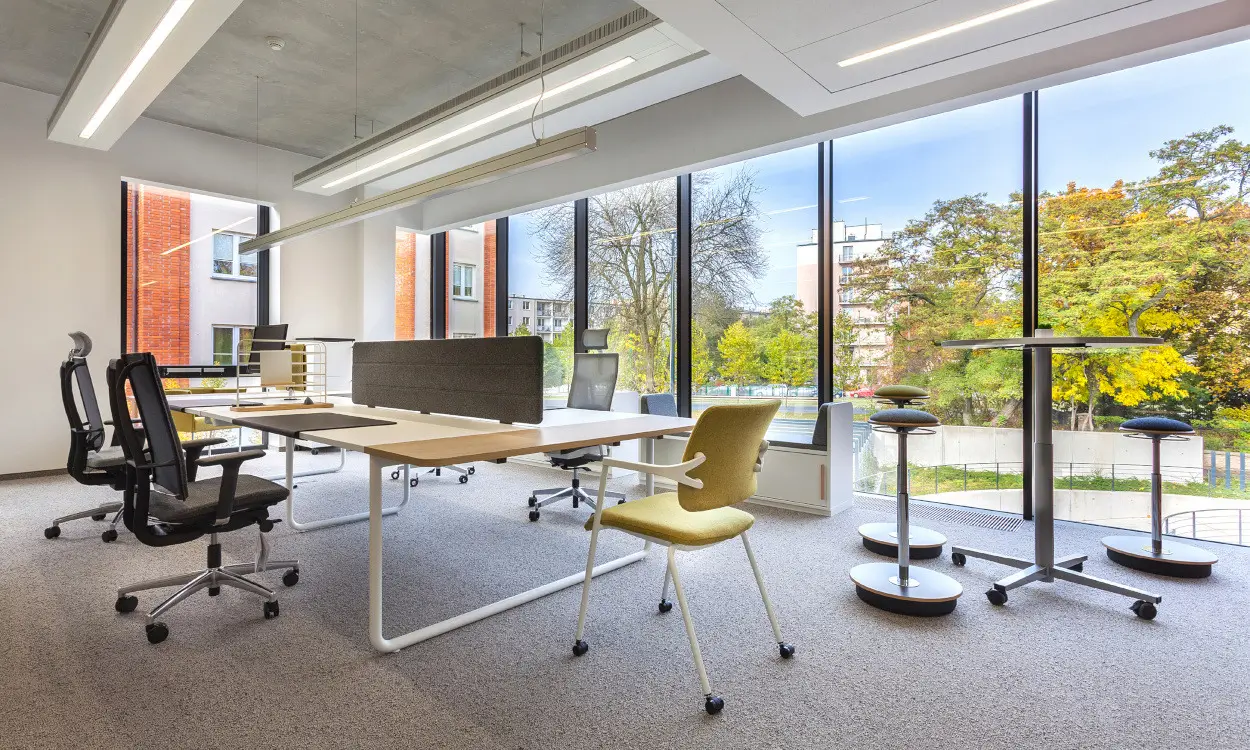 Kleines Büro für zwei Personen mit höhenverstellbaren Schreibtischen und Akustik-Trennwand